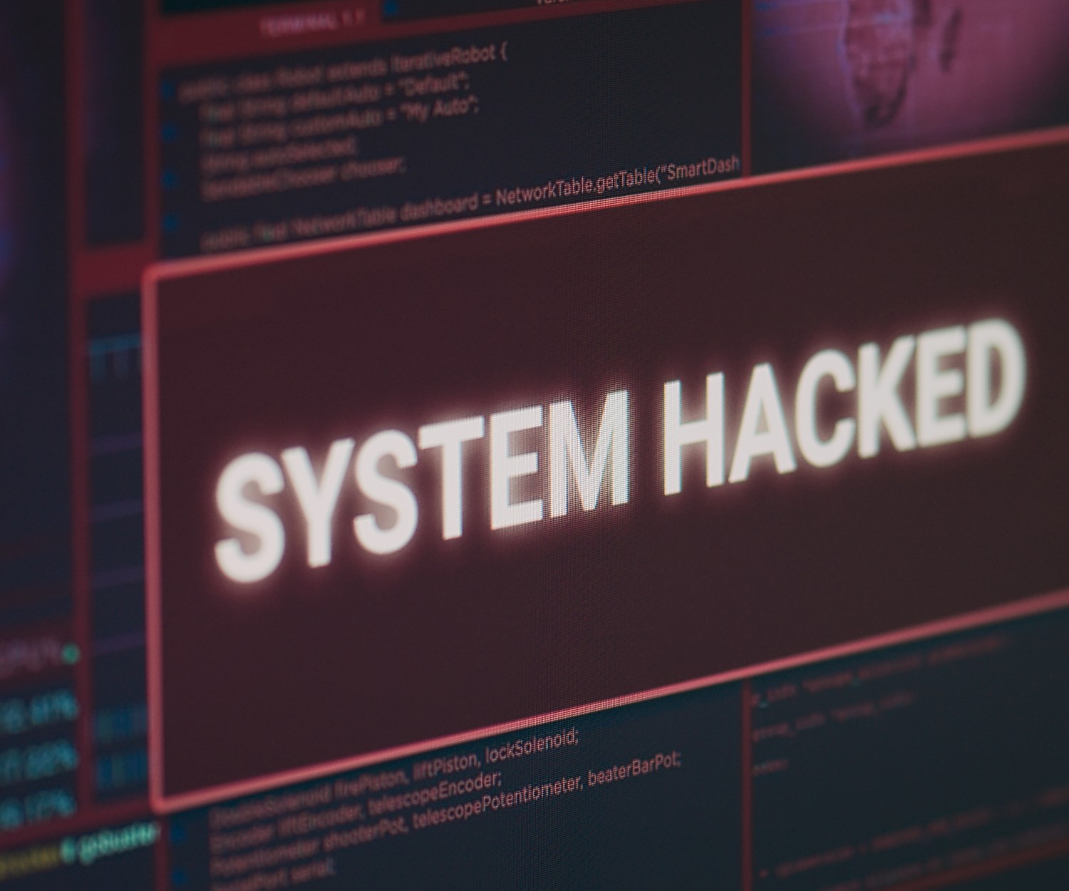 Computer monitor showing hacked system alert message flashing on screen, dealing with hacking and cyber crime attack. Display with security breach warning and malware threat. Close up.